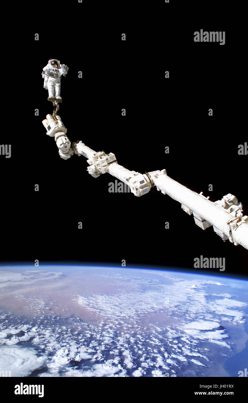 Astronaut Stephen K. Robinson, STS-114 Missionsspezialist verankert an einem Fuß Fessel auf der erweiterten internationalen Raumstation Canadarm2, beteiligt sich an der Mission dritten Tagung des Extravehicular Activity (EVA). Die Schwärze des Raumes und der Erde Horizont bilden die Kulisse für das Bild. NASA-Foto Stockfoto