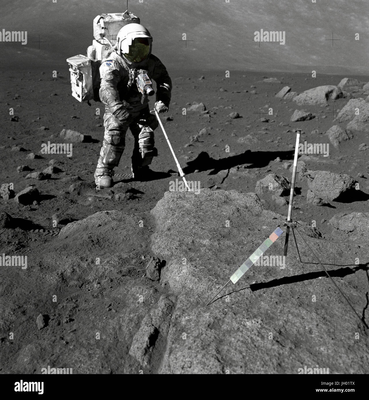 Schmitt mit Lunar Schmutz bedeckt. Geologe-Astronaut Harrison Schmitt, Pilot der Mondlandefähre Apollo 17, nutzt eine einstellbare Sampling-Schaufel abzurufenden lunare Proben während der zweiten Extravehicular Activity (EVA-2), auf Station 5 bei den Taurus - Littrow-Landeplatz. Der Zusammenhalt des lunar Bodens wird durch das "schmutzige" auftreten von Schmitts Raumanzug heraus geboren. Ein Gnomon ist oben auf dem großen Felsen im Vordergrund. Gnomon Stadien Rute auf einem Stativ montiert und dient als Indikator für die Schwerkraft Vektor und liefert genaue vertikale Referenz und kalibriert Länge für die Bestimmung der Größe Stockfoto