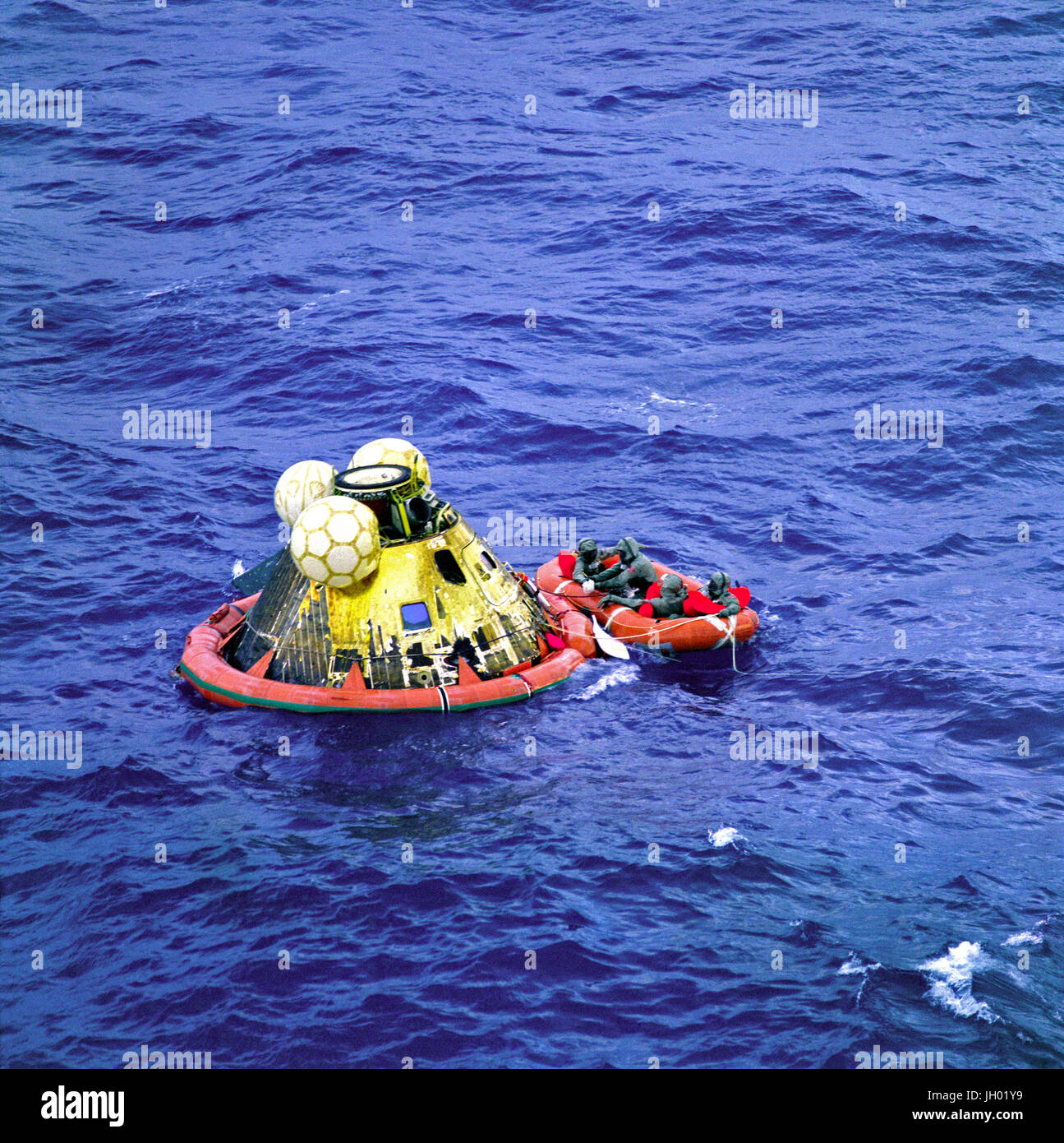 Die Apollo 11 Crew warten auf Abholung von einem Hubschrauber von der USS Hornet, erstklassige Erholung Schiff für die historische Mission der Apollo 11 Mondlandung. Der vierte Mann in der Rettungsinsel ist ein United States Navy underwater Demolition Team Schwimmer. Alle vier Männer tragen biologischen Isolation Kleidungsstücke (BIG). Apollo-11-Kommandokapsel "Columbia" mit Astronauten Neil A. Armstrong, Michael Collins und Edwin E. Aldrin Jr. wasserte am 11:49 (CDT), 24. Juli 1969, ca. 812 Seemeilen südwestlich von Hawaii und nur 12 Seemeilen von der USS Hornet. Stockfoto