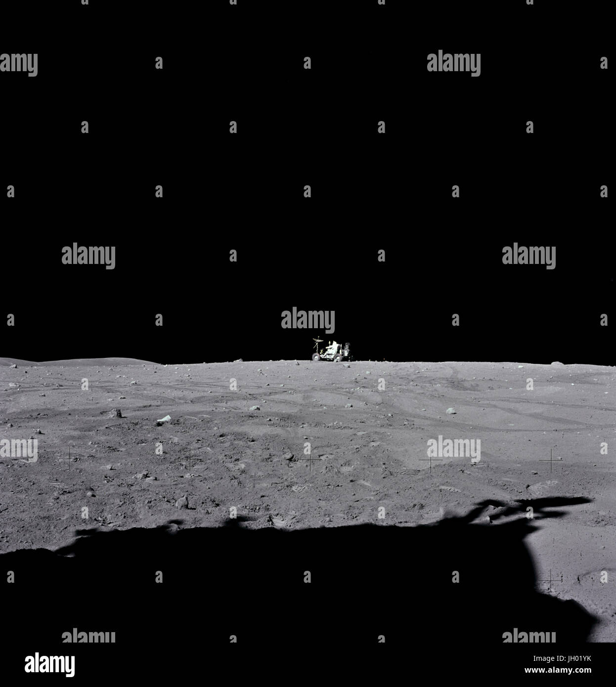 Astronaut John W. Young, Apollo 16 Mission Kommandant, fährt die "Rover", Lunar Roving Vehicle (LRV) zu seinen endgültigen Parkplatz kurz vor dem Ende der dritten Extravehicular Activity (EVA-3) am Landeplatz Descartes. Astronaut Charles M. Duke Jr., Pilot der Mondlandefähre, nahm dieses Foto auf der Suche nach Süden. Die Flanke von Stone Mountain kann am Horizont auf der linken Seite zu sehen. Der Schatten der Mondlandefähre "Orion" ist im Vordergrund zu sehen. Fotograf: NASA / Charles M. Herzog Jr. Stockfoto