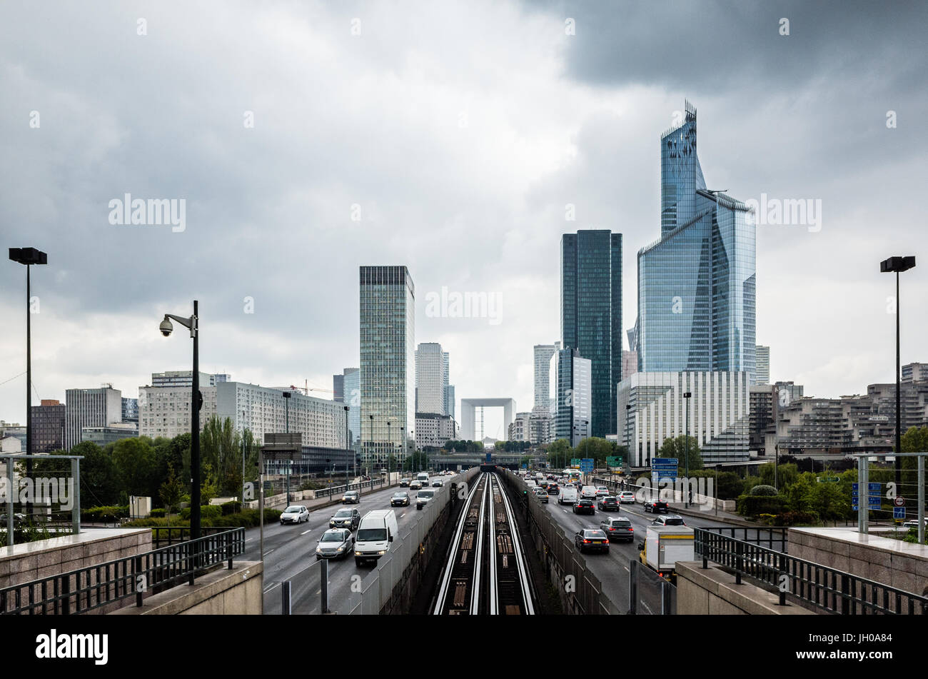 Paris La Defense Business District skyline unter einem stürmischen Himmel mit dem Grande Arche und der U-Bahn und Autobahn auf der Neuilly Brücke. Stockfoto