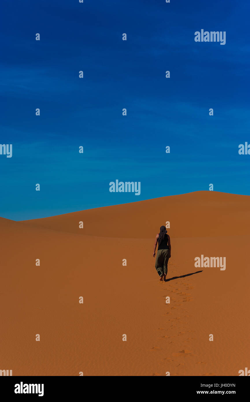 Mädchen-Spaziergang im Erg Chebbi Wüste Sahara in der Nähe von Merzouga, Marokko Stockfoto