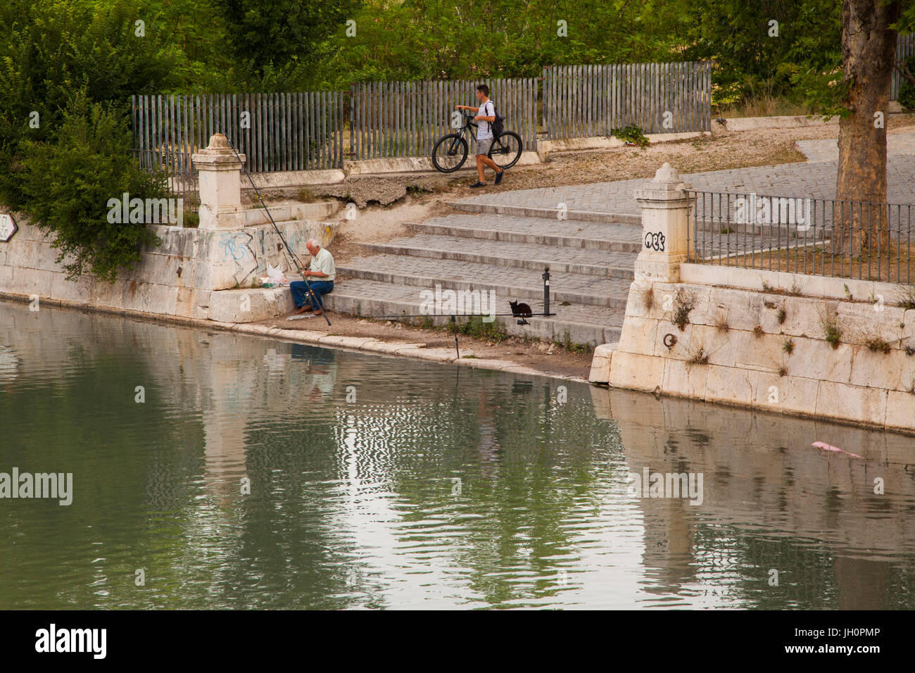 Angeln der Schritte auf dem Gelände des königlichen Palast von Aranjuez Madrid Provinz der spanischen von junge mit Fahrrad und eine Katze beobachtet man Stockfoto