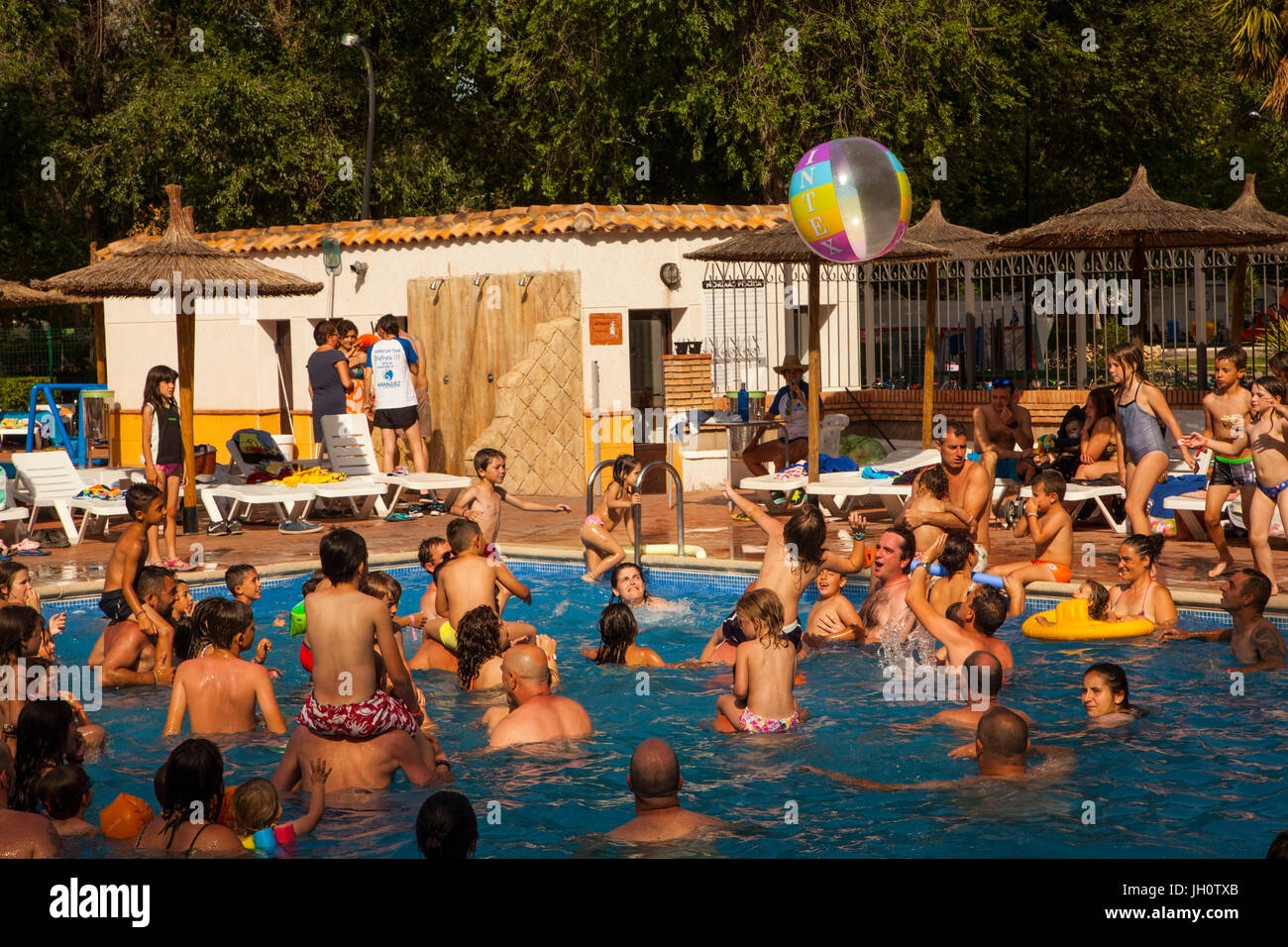 Die Familie Spaß haben in einem spanischen Campingplatz Schwimmbad spielen eine Kugel Spiel Stockfoto