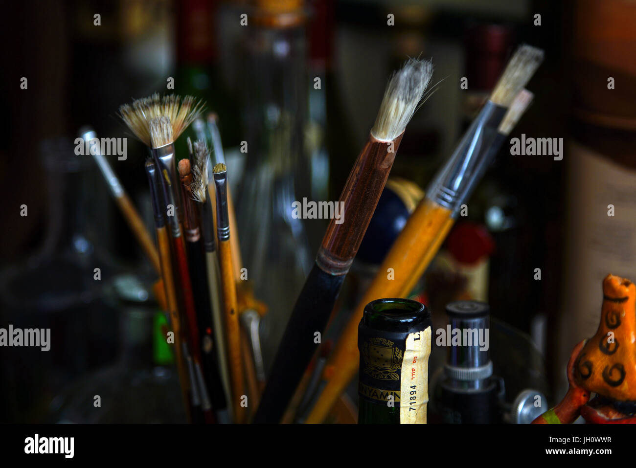 Des Künstlers Pinsel im Container auf einem Arbeitstisch Stockfoto