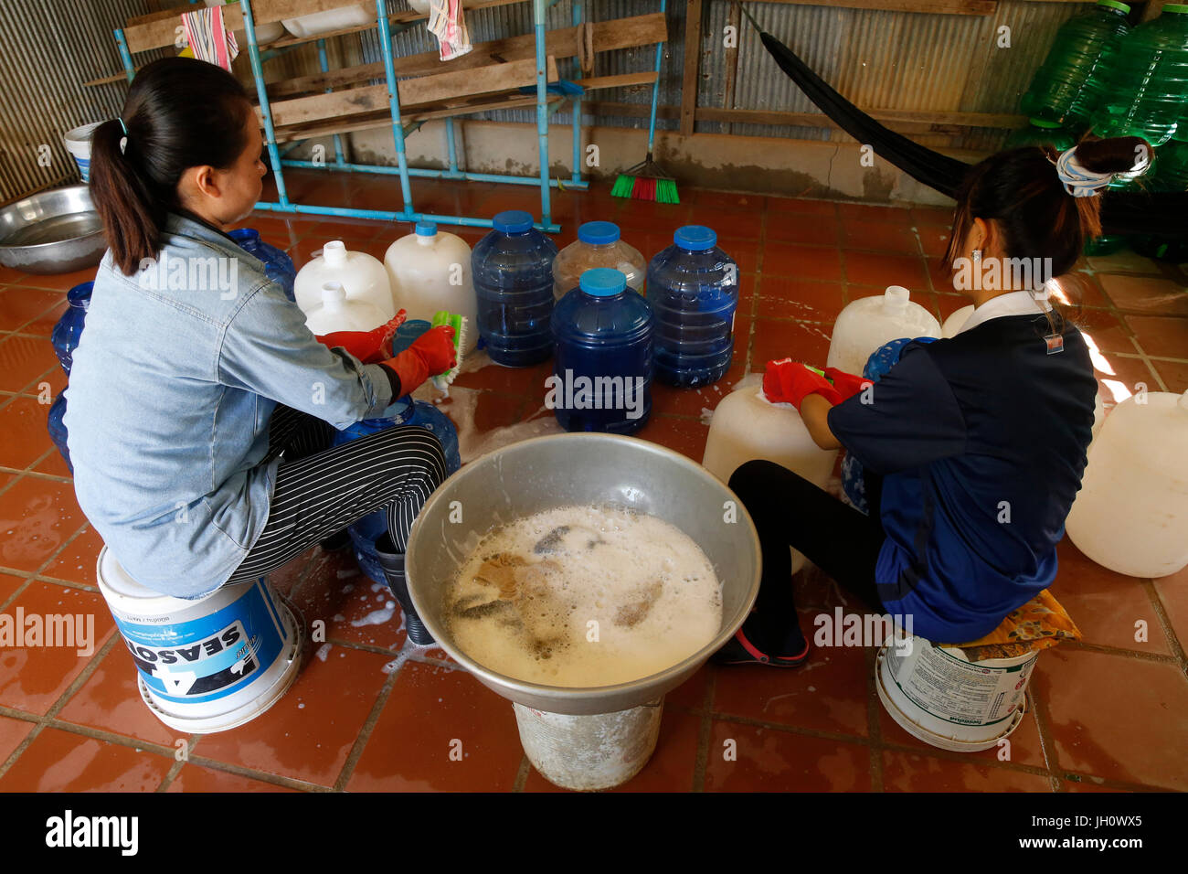 1001 Brunnen Wasser Unternehmen. Mitarbeiter Reinigung Korbflaschen. Kambodscha. Stockfoto