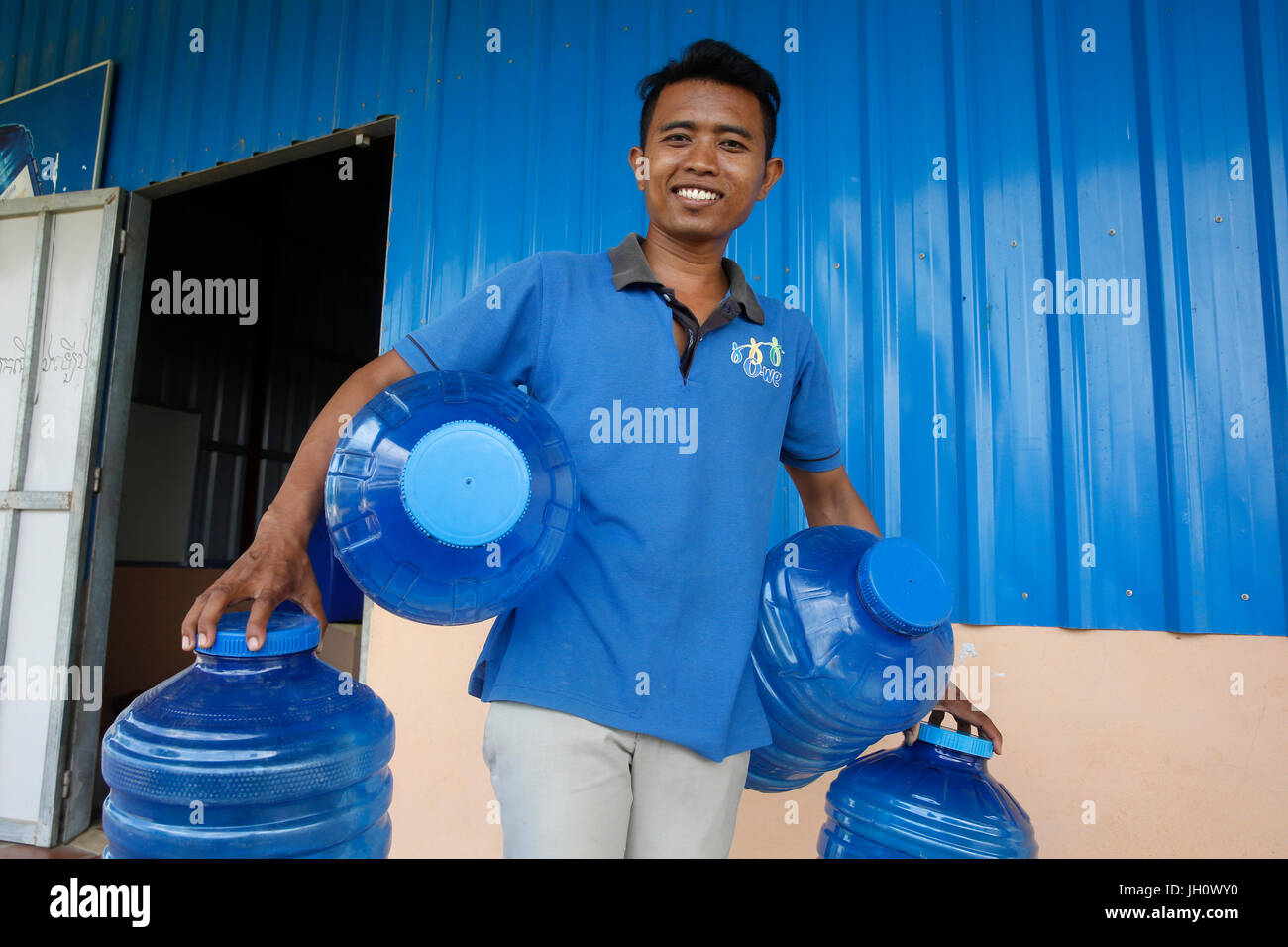 1001 Brunnen Wasser Unternehmen. Mitarbeiter tragen Korbflaschen. Kambodscha. Stockfoto