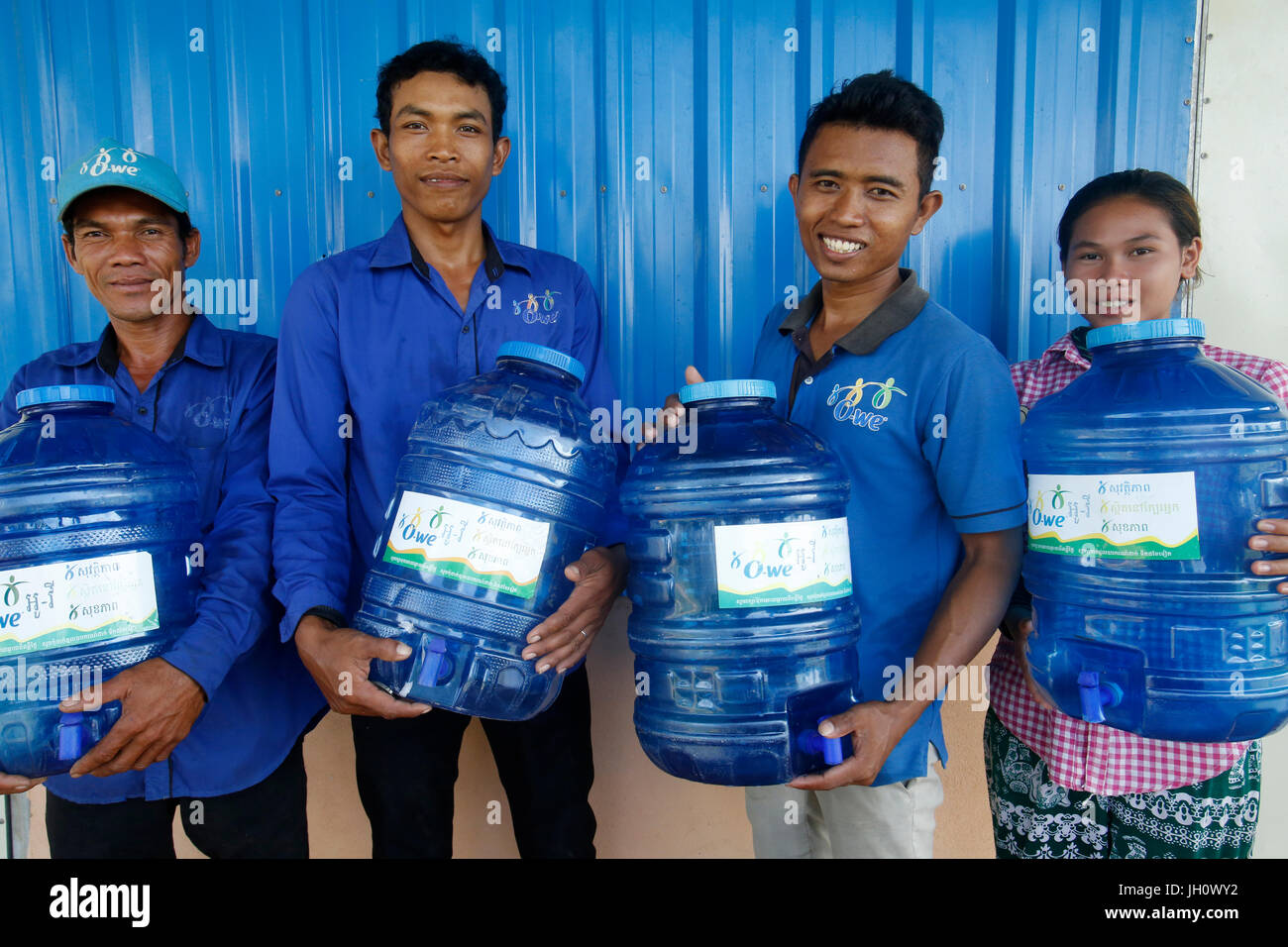 1001 Brunnen Wasser Unternehmen. Mitarbeiter tragen Korbflaschen. Kambodscha. Stockfoto