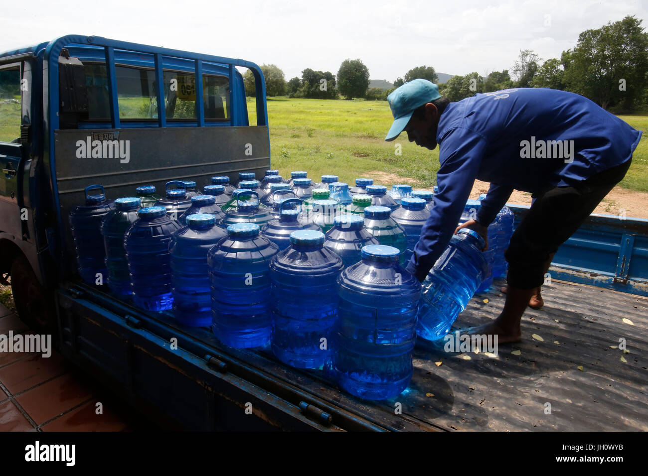 1001 Brunnen Wasser. Mitarbeiter Korbflaschen laden auf einen Lastwagen. Kambodscha. Stockfoto
