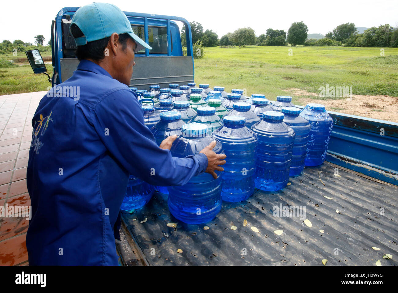 1001 Brunnen Wasser. Mitarbeiter Korbflaschen laden auf einen Lastwagen. Kambodscha. Stockfoto