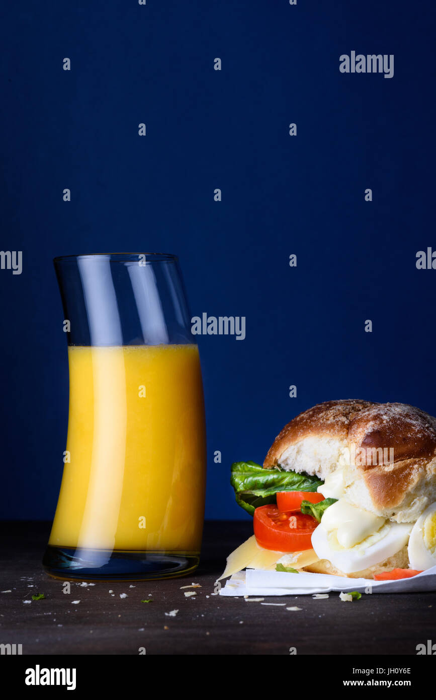 Frühstücks-Ei-Sandwich mit Orangensaft. Gesunder Snack am Küchentisch. Kopieren Sie Raum, close-up. Stockfoto