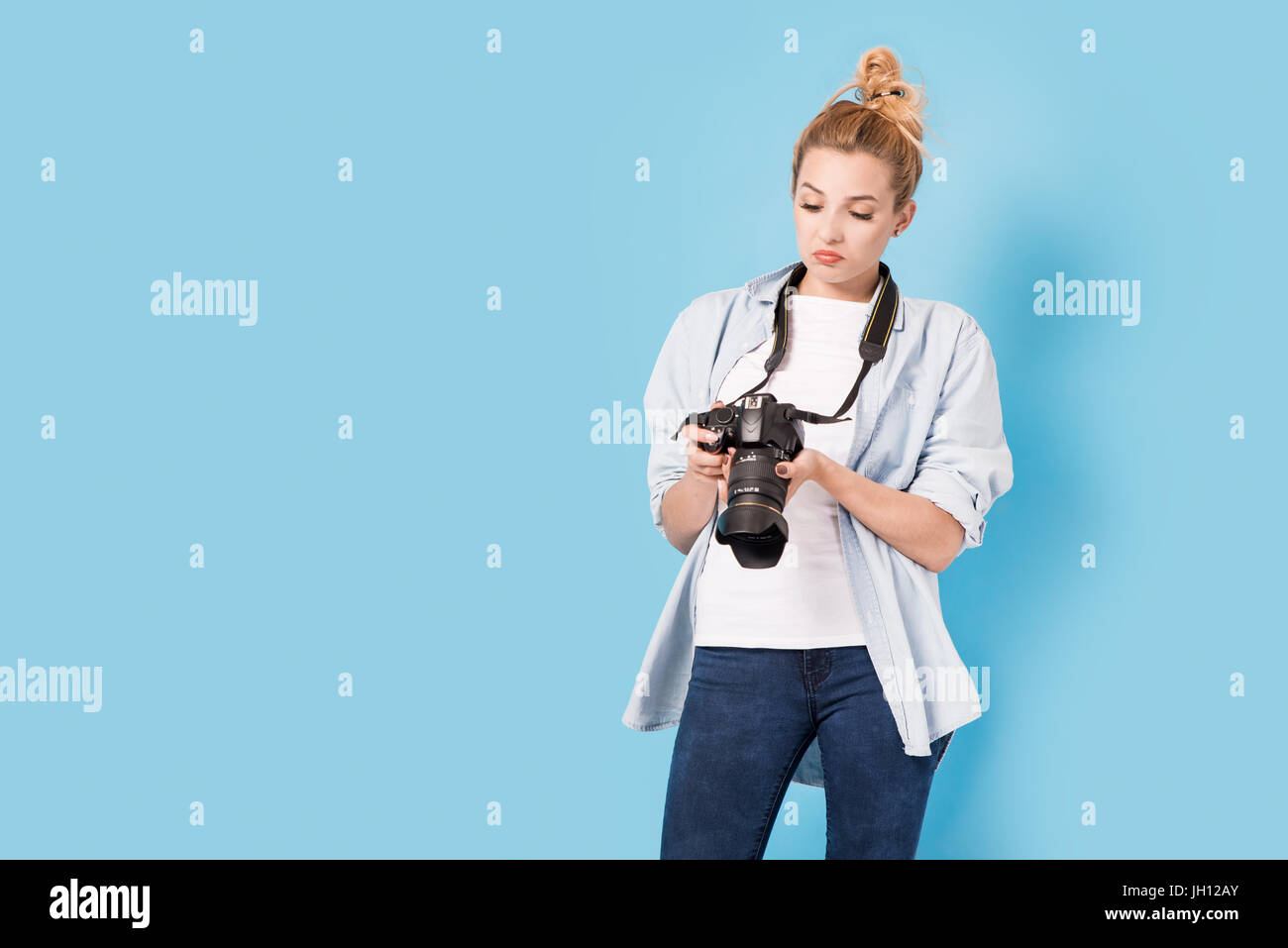 Fotografin ist über ihre Arbeit zufrieden. Modell isoliert auf einem blauen Hintergrund mit Kopie Raum Stockfoto