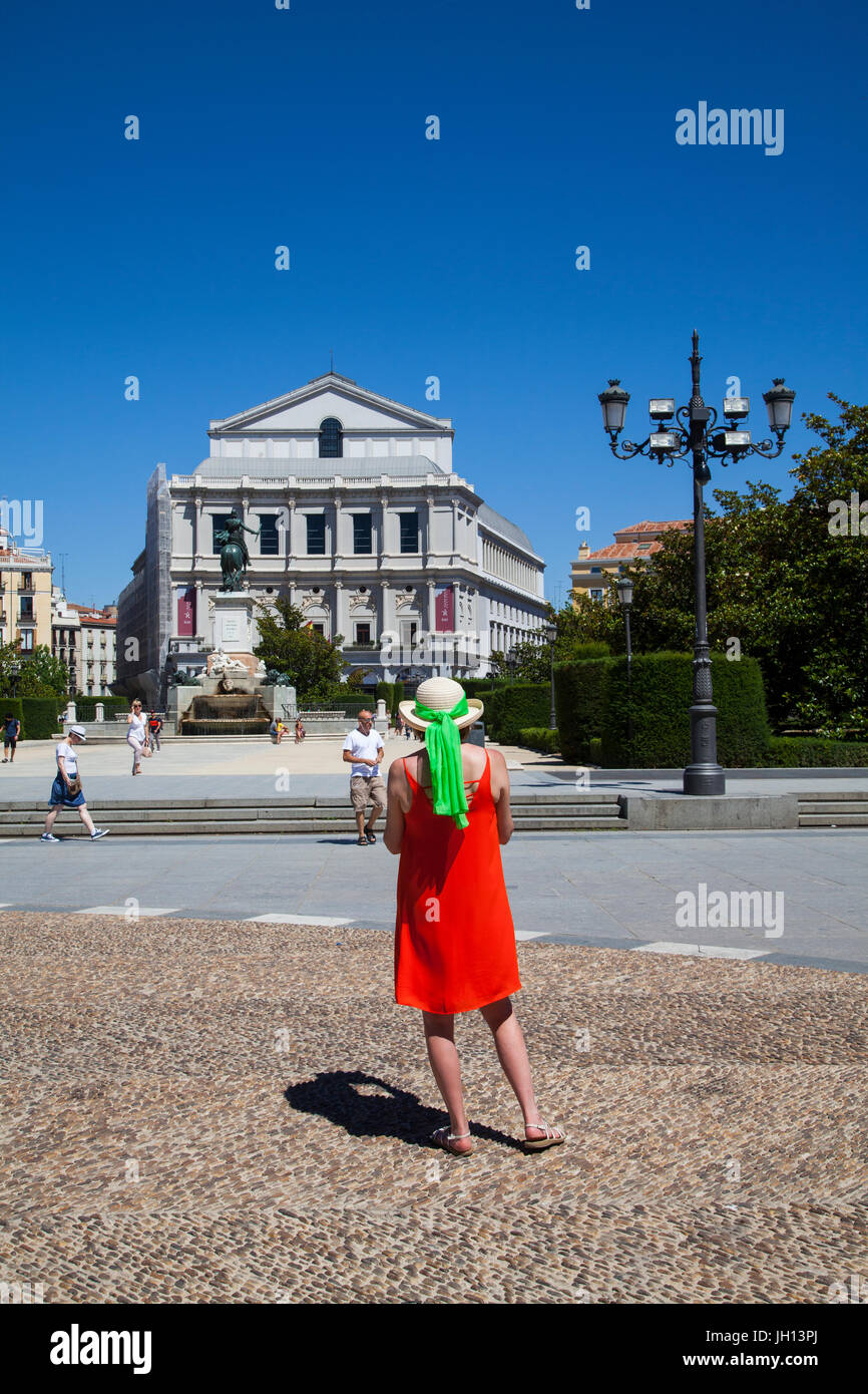 Frau in einem roten Kleid steht vor dem Teatro Real / Theatre Royal und das Denkmal für Felipe IV in Madrid Spanien Stockfoto