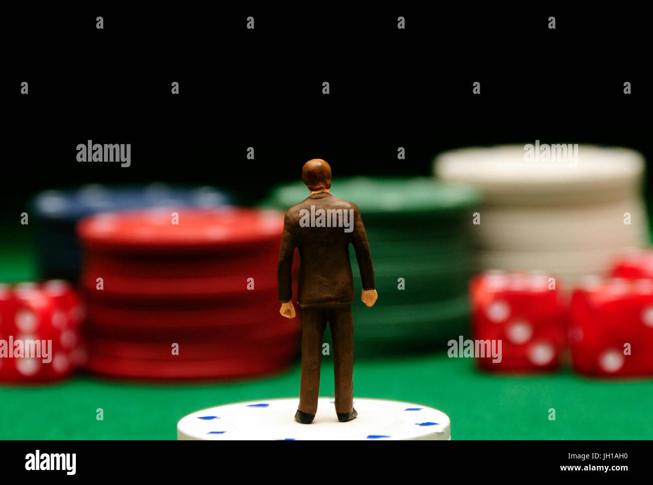 männliche Miniatur Figur stehend auf Casino-Chips, Wetten und wirtschaftliches Risiko-Konzept Stockfoto