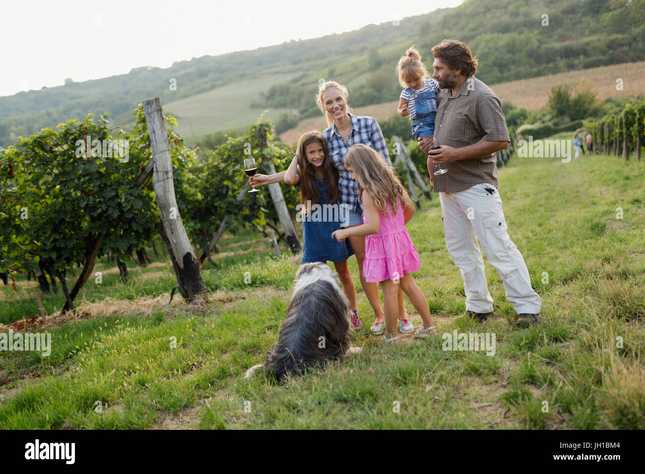 Glückliche Familie genießt Spaziergang im Weinberg Stockfoto