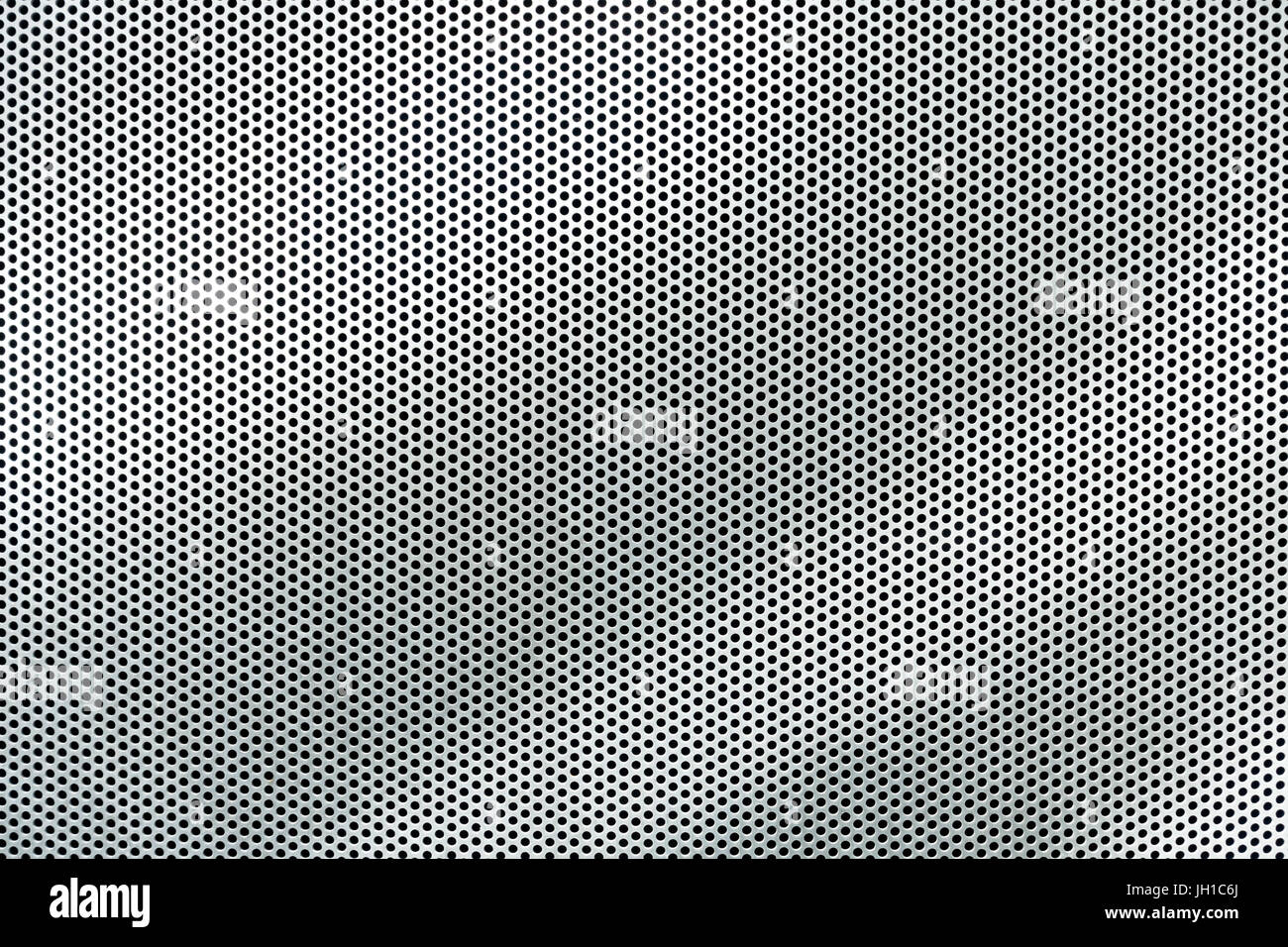 Grau Metall Hintergrund, runde perforiertes Metall Textur mit Reflexionen Stockfoto