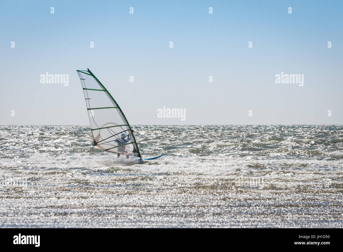 Wellenreiten in ein leeres Meer Windsurfer Stockfoto