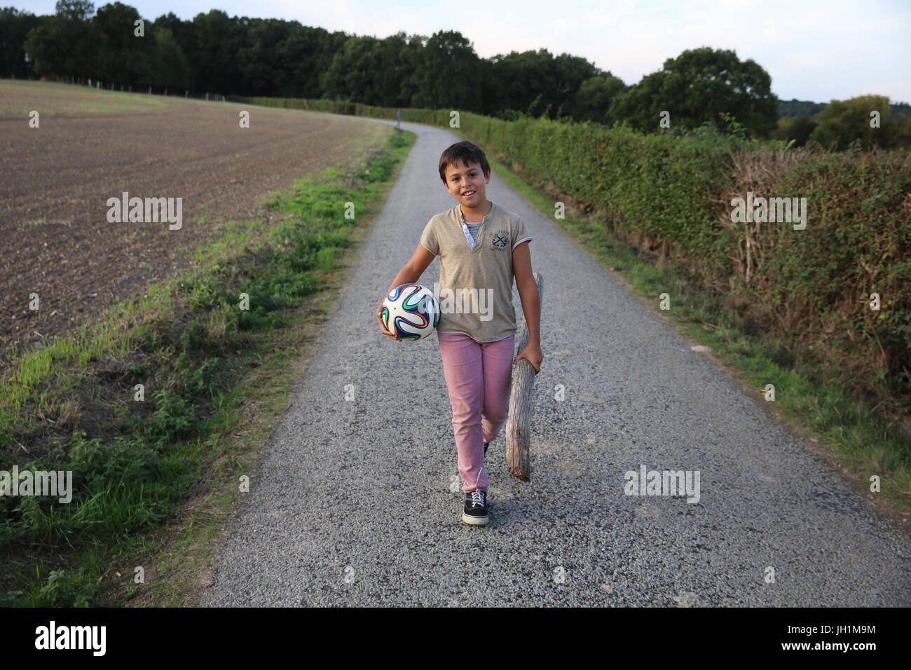 10-Year-Old Boy zu Fuß auf einer Landstraße. Frankreich. Stockfoto