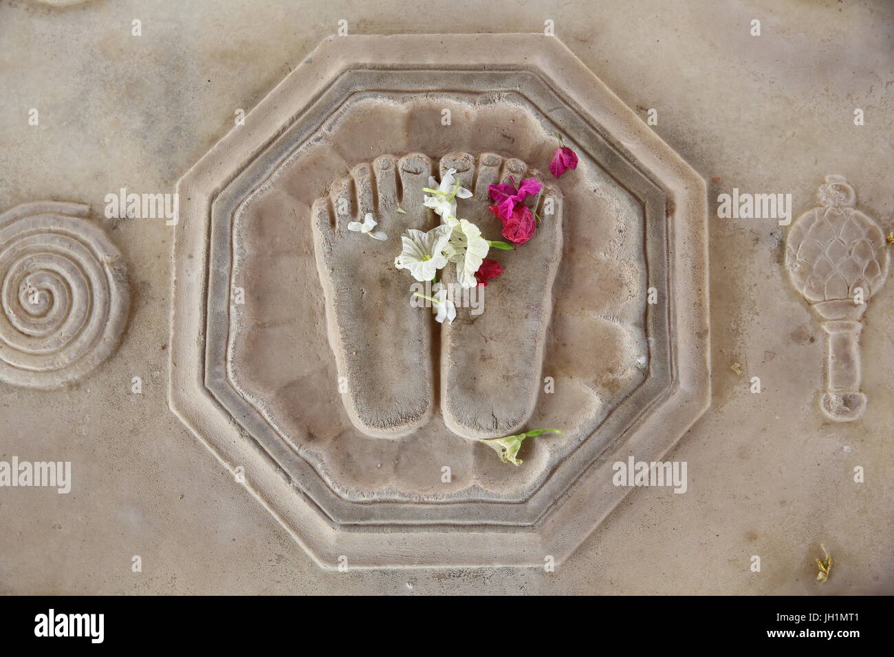 Blume auf Krishnas Lotusfüßen eingraviert auf dem Boden in Kusum Sarovar. Indien. Stockfoto