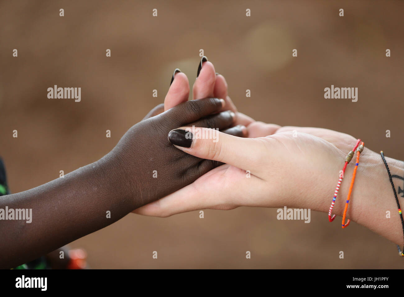 Humanitäre Arbeiter des Kindes Hand hält. Togo. Stockfoto