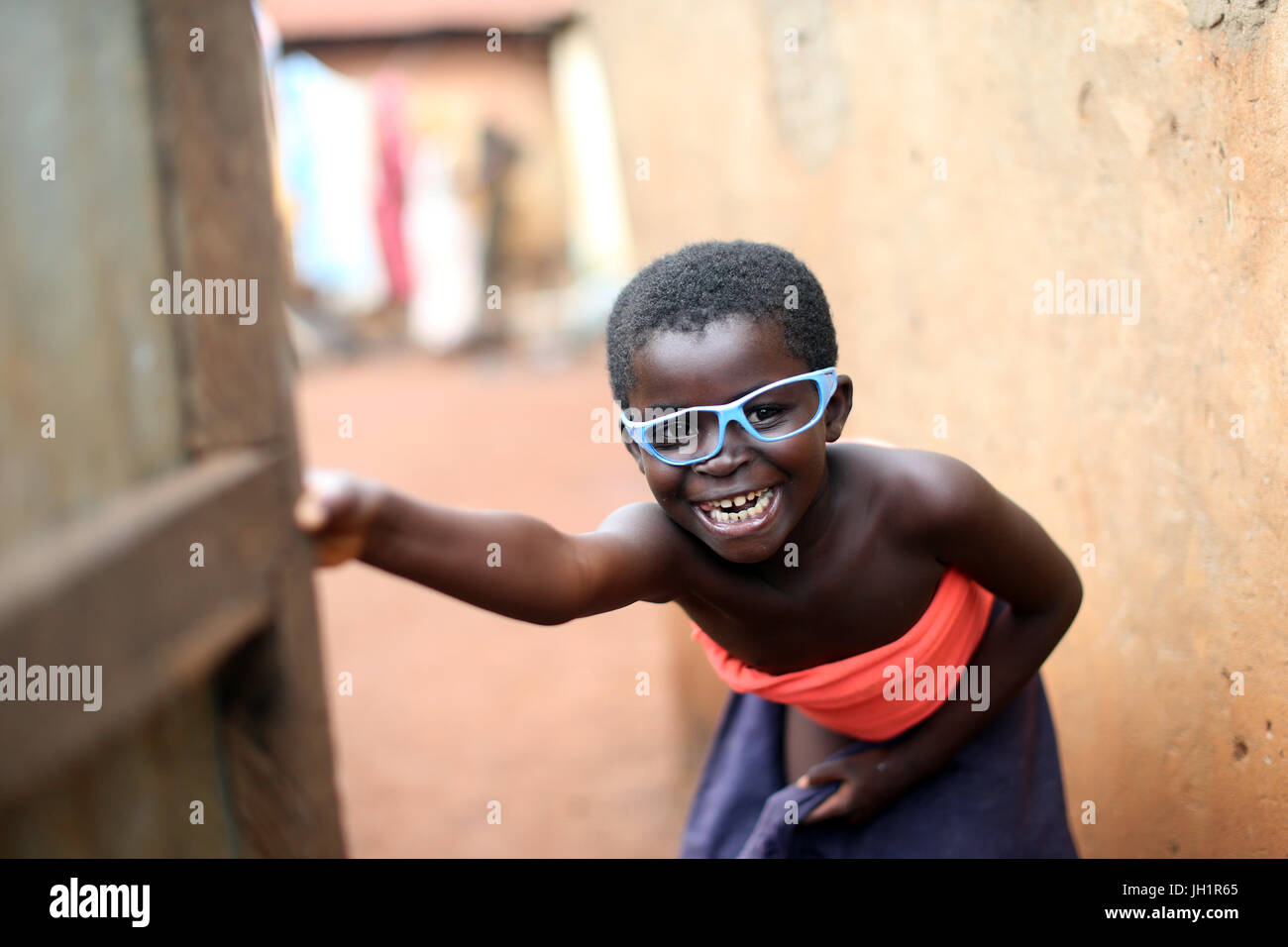 Lächelnde afrikanisches Mädchen mit blauen Brillen.  Togo. Stockfoto