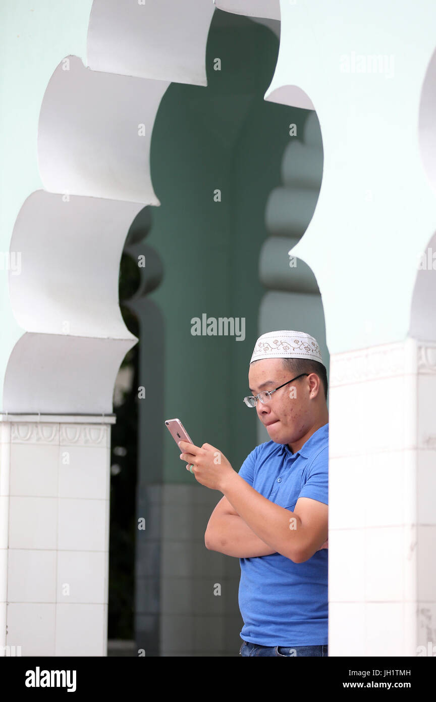 Masjid Musulman (Saigon-Zentral-Moschee). Mann mit einem Smartphone.  Ho-Chi-Minh-Stadt. Vietnam. Stockfoto