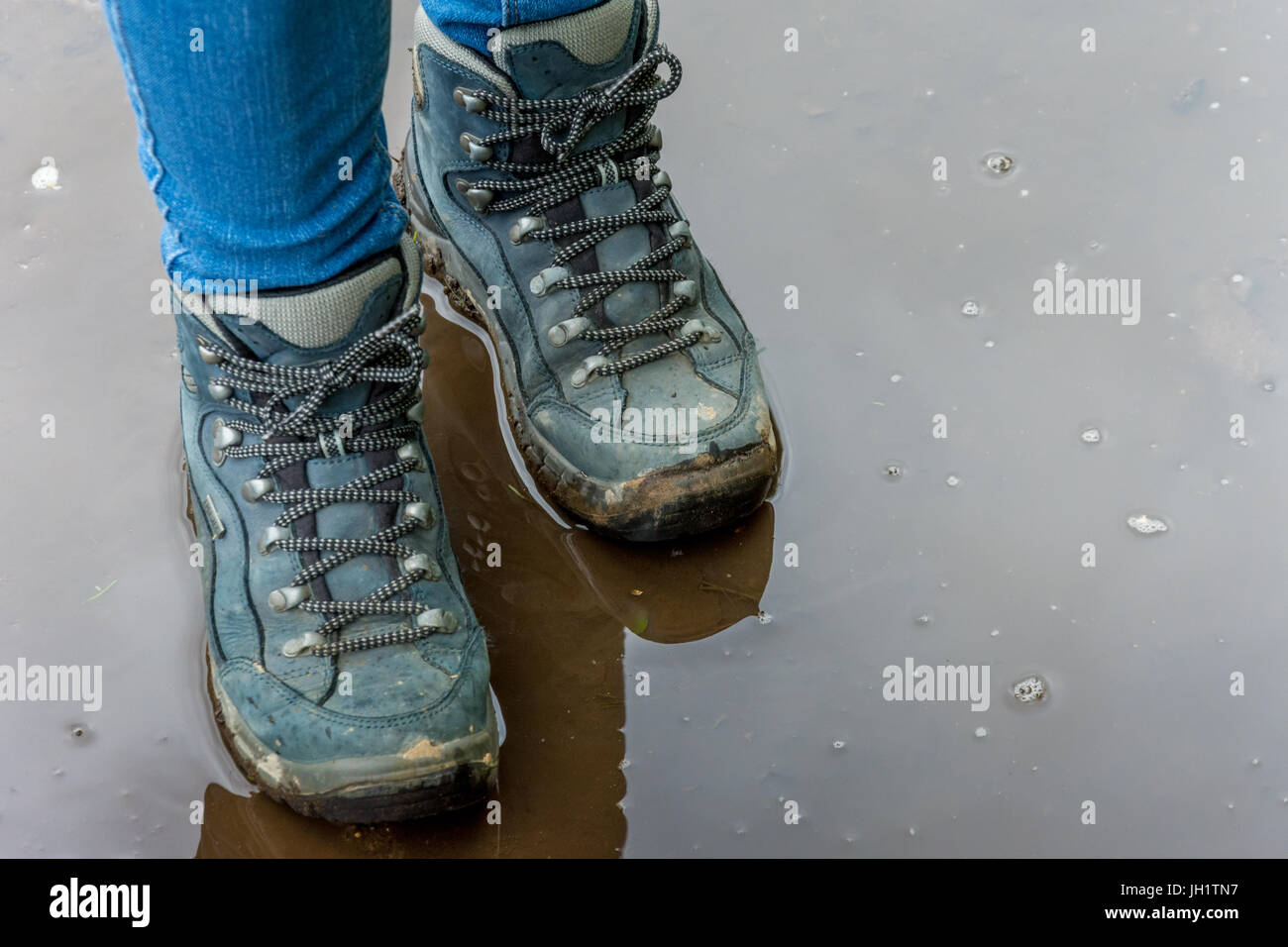 Stiefel Stand in Pfütze, nasse Füße Stockfoto