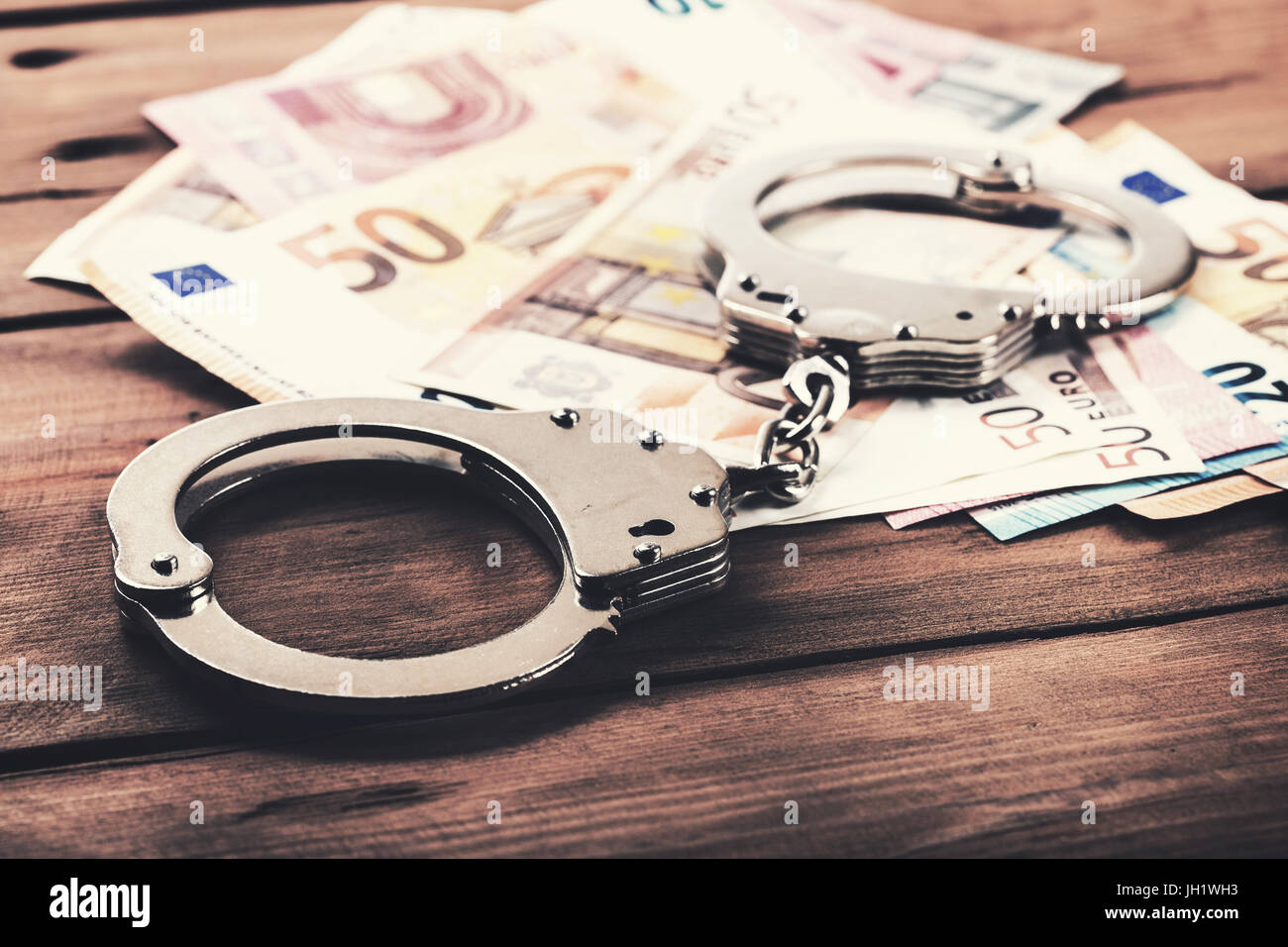 Finanzkriminalität Konzept - Geld und Handschellen auf dem Tisch Stockfoto
