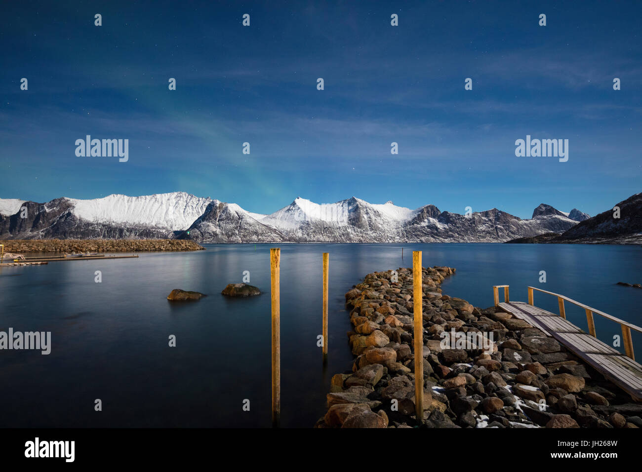 Sterne der Polarnacht umrahmen das gefrorene Meer, umgeben von schneebedeckten Gipfeln, Mefjord Berg, Senja, Troms Grafschaft, Norwegen, Scandinavia Stockfoto