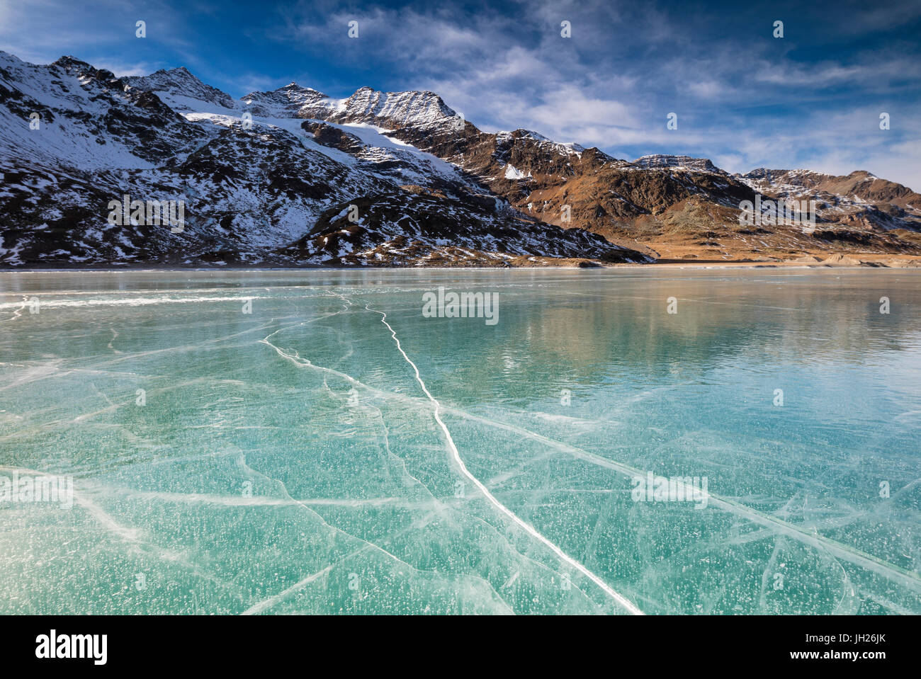 Die schneebedeckten Gipfel umrahmen das gefrorene türkisfarbene Wasser des White Lake, Berninapass, Kanton Graubünden, Engadin, Schweiz Stockfoto