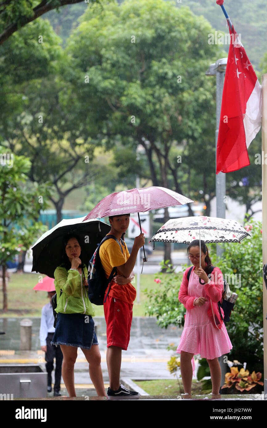 Kinder auf nassen Straße Monsunzeit.  Singapur. Stockfoto