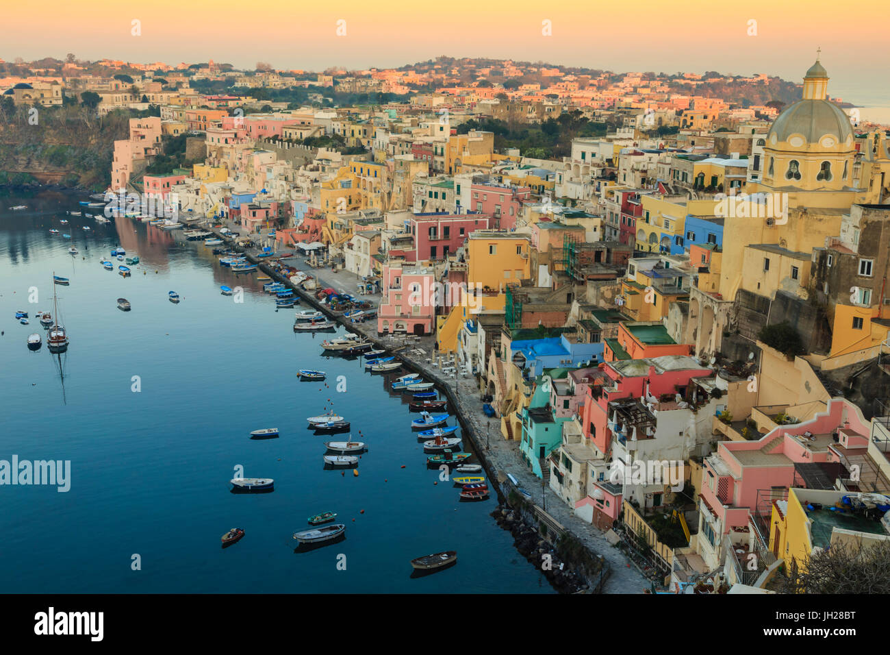 Marina Corricella bei Sonnenaufgang, Fischerdorf, bunte Häuser, Kirche und Hafen Boote, Insel Procida, Neapel, Italien Stockfoto