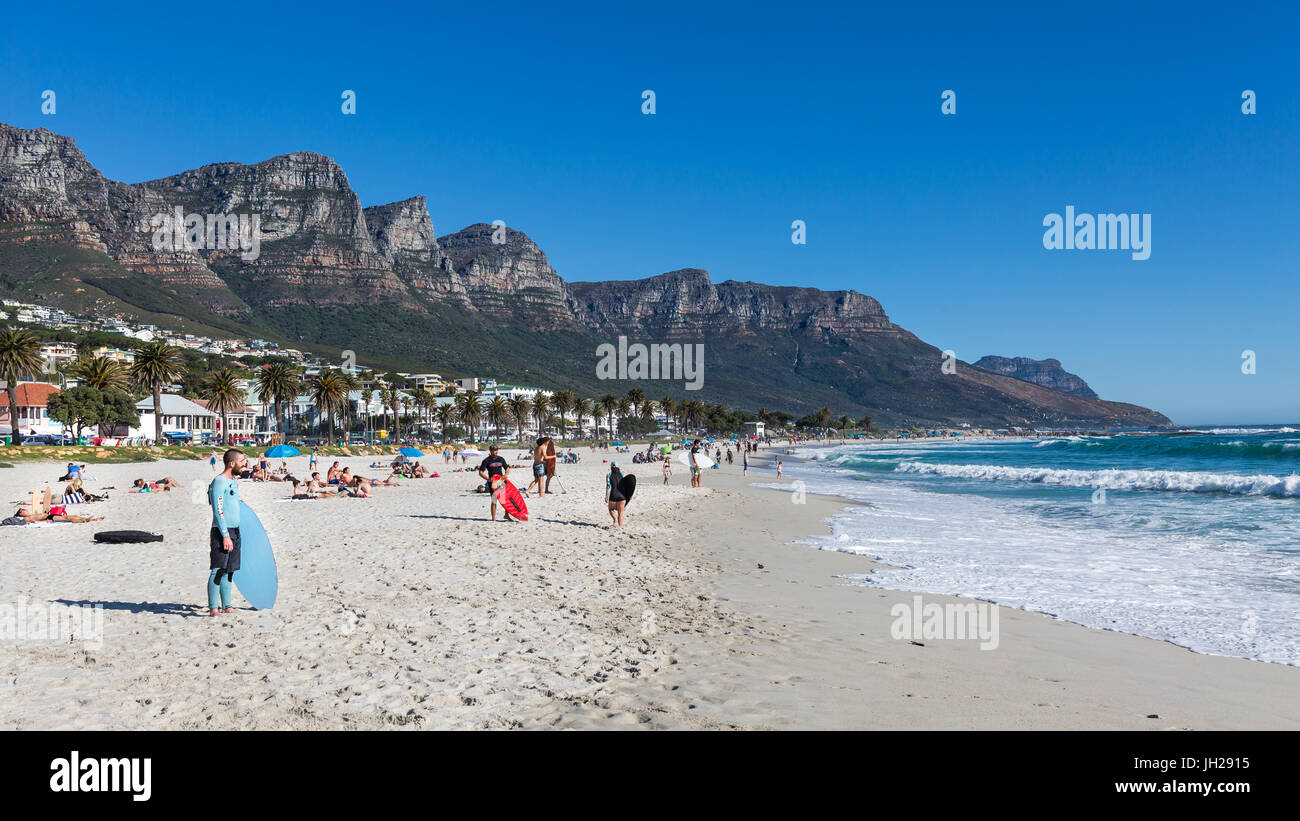 Skimboarders warten auf eine Welle an einem sonnigen Tag in Camps Bay Beach, Cape Town, Western Cape, Südafrika, Afrika Stockfoto