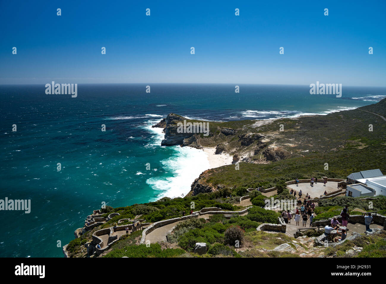 Zeigen Sie zurück zu der Kap-Halbinsel, mit Touristen Walkning nach unten vom Leuchtturm am Cape Point, in der Nähe von Cape Town, Südafrika an Stockfoto