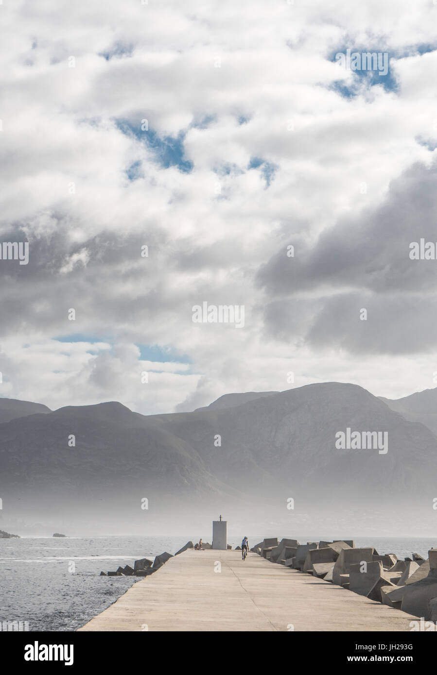 Wie Sonne bricht am frühen Morgennebel, Radfahrer am Ende des Piers, neuer Hafen, Hermanus, Südafrika, Afrika Stockfoto