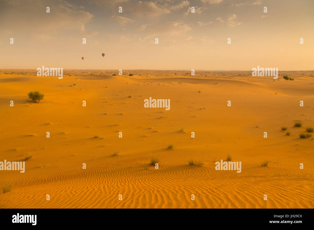 Heißluftballons über Sanddünen bei Sonnenaufgang in der Wüste von Dubai, Dubai, Vereinigte Arabische Emirate, Naher Osten Stockfoto
