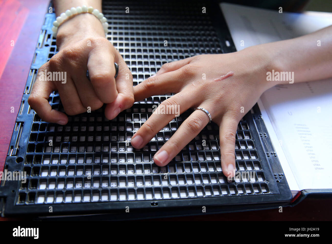 Vietnam.  Zentrum für blinde Kinder.  Mädchen schreiben Braille. Stockfoto