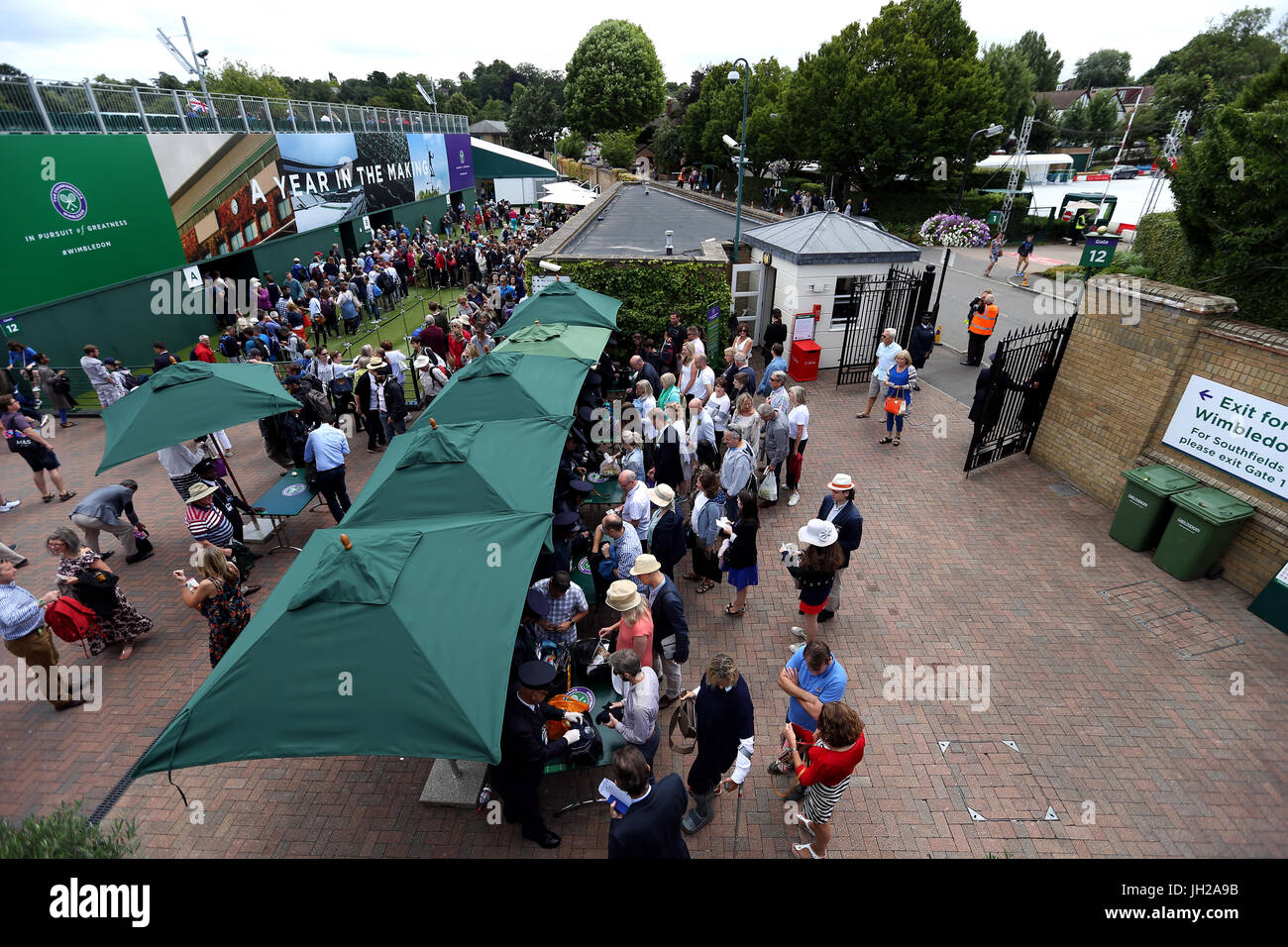 Zuschauer in die Warteschlange an Sicherheit beim Eintritt in die Tore am Tag neun der Wimbledon Championships in The All England Lawn Tennis and Croquet Club, Wimbledon. Stockfoto