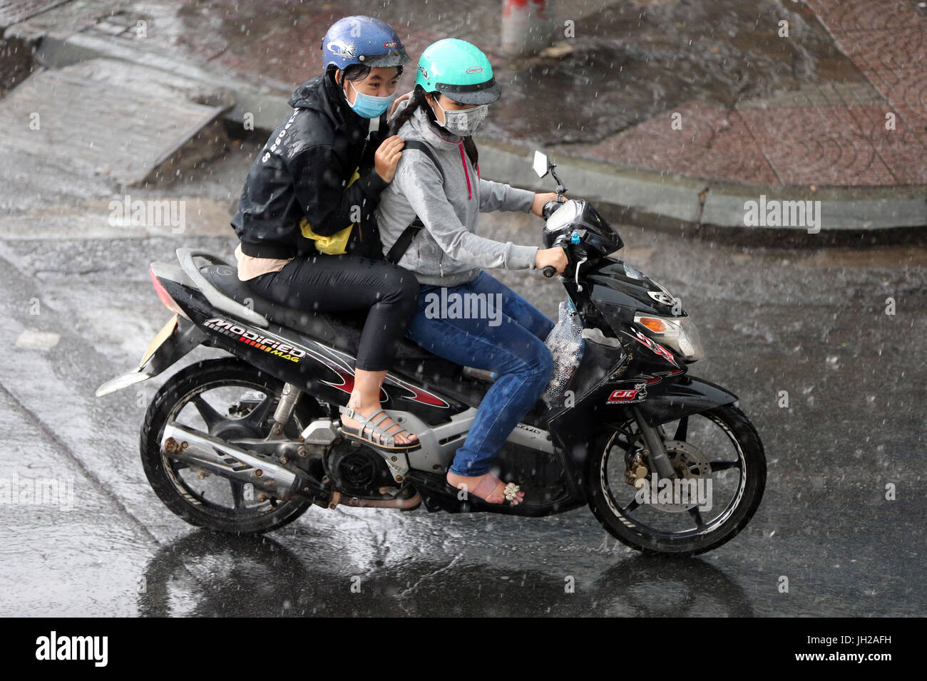 Schweren Monsunregen. Motorroller auf Saigon Street. Vietnam. Stockfoto