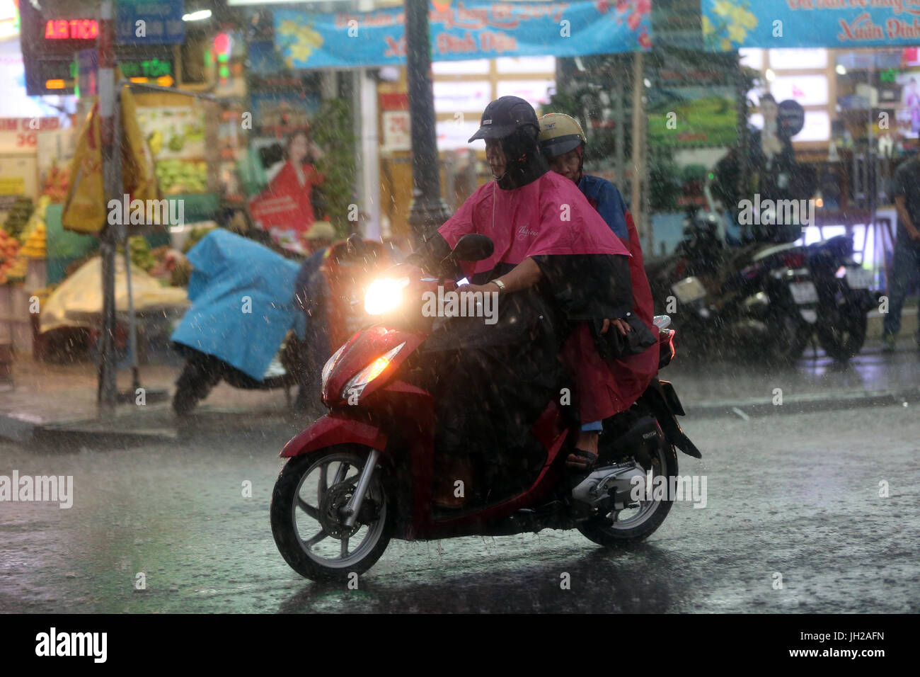 Schweren Monsunregen. Motorroller auf Saigon Street. Vietnam. Stockfoto