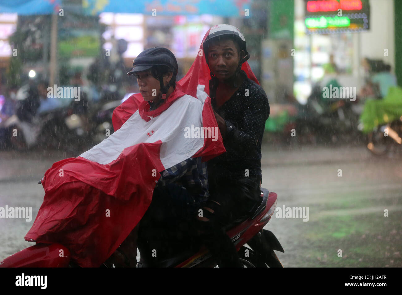 Schweren Monsunregen. Motorroller auf Saigon Street. Vietnam. Stockfoto