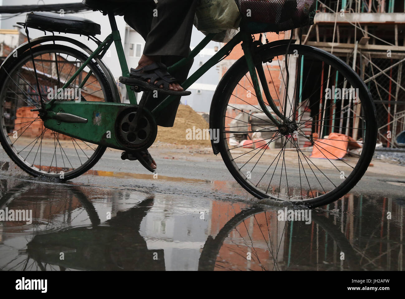Schweren Monsunregen. Fahrrad auf Saigon Street. Vietnam. Stockfoto