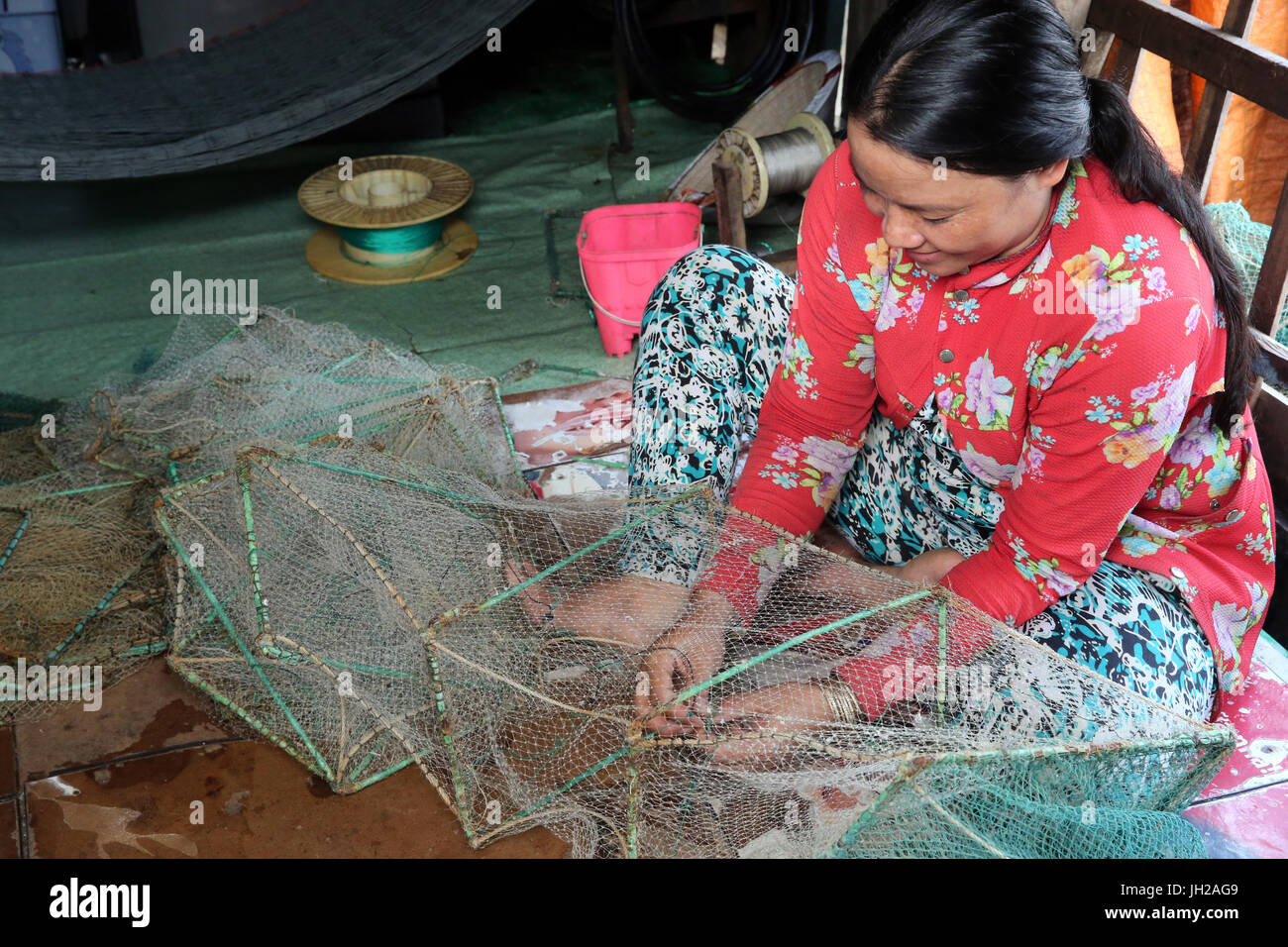 Frau vor einem Fischernetz. Vietnam. Stockfoto