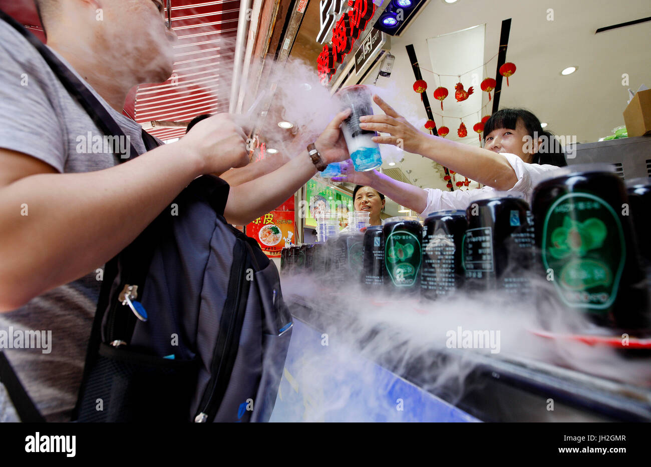 Shanghai, China. 12. Juli 2017. Alkoholfreie Getränke gibt einen Verkäufer an einen Kunden in Shanghai, Ost-China, 12. Juli 2017. Shanghai aktualisiert seine Hitze-Warnung am Mittwoch. Bildnachweis: Fang Zhe/Xinhua/Alamy Live-Nachrichten Stockfoto