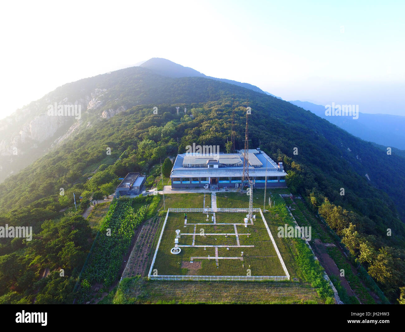 (170712)--ZHENGZHOU, 12. Juli 2017 (Xinhua)--Luftbild, aufgenommen am 11. Juli 2017 zeigt die nationalen klimatologischen Referenzstation auf Paomaling von Songshan Berg in Dengfeng City, Zentral-China Henan Provinz. Die nationalen klimatologischen Referenzstation auf Songshan Berg, mit einer Geschichte von 61 Jahren und 1.178 m Seehöhe ist die nur hohen Berg klimatologischen Referenzstation in Henan. 52-j hrige Wang Yantao, der Leiter der Station, hat hier seit 32 Jahren gearbeitet. Trotz der Strapazen der Arbeit ist hier, wie der einzige Transport zum Bahnhof Stockfoto