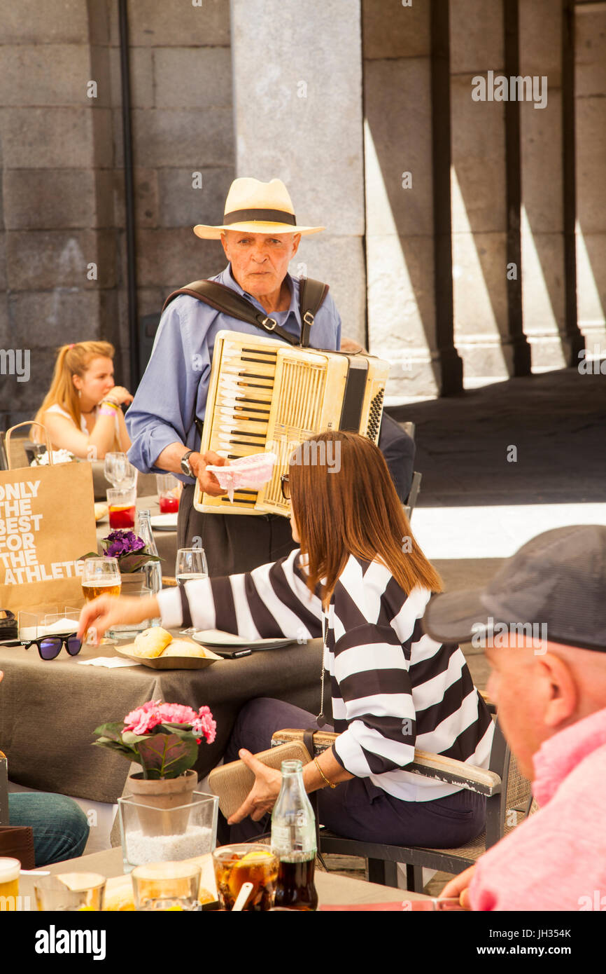 Mann in einem Strohhut Piano Akkordeon zu spielen, zu Essen in einem Restaurant auf der Piazza-Bürgermeister / Plaza Mayor Madrid Stockfoto
