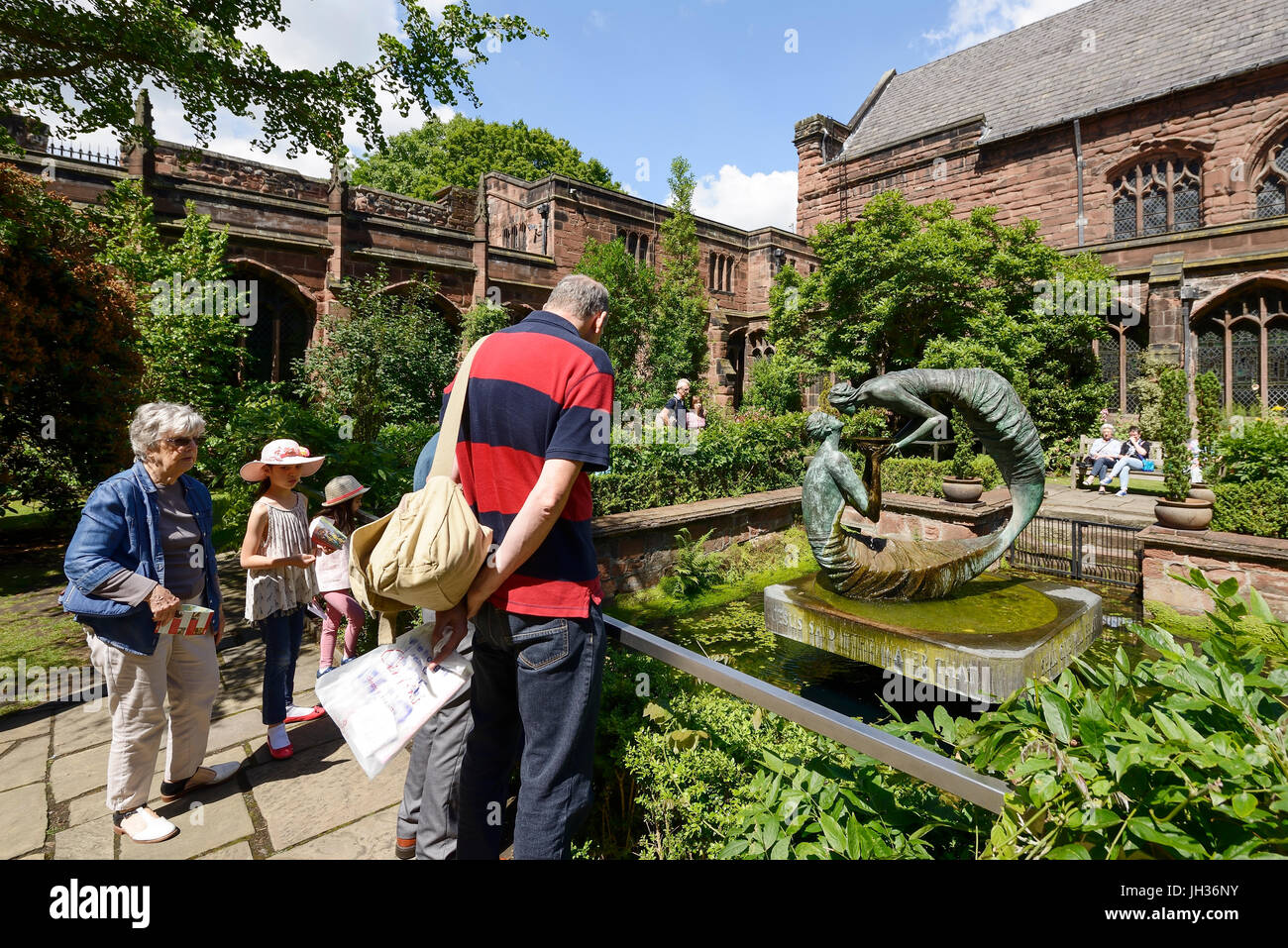 Besucher bewundern das Wasser des Lebens Skulptur im Klostergarten in Chester Cathedral UK Stockfoto