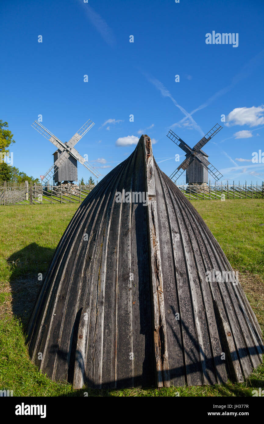 Alte Boot-Installation und hölzerne Windmühlen im Hintergrund. Insel Saaremaa, Estland. Stockfoto