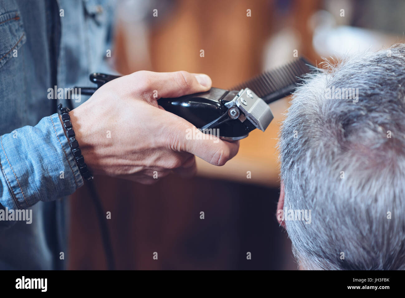 Nahaufnahme von einer Haarschneidemaschine in Barbiere Händen Stockfoto