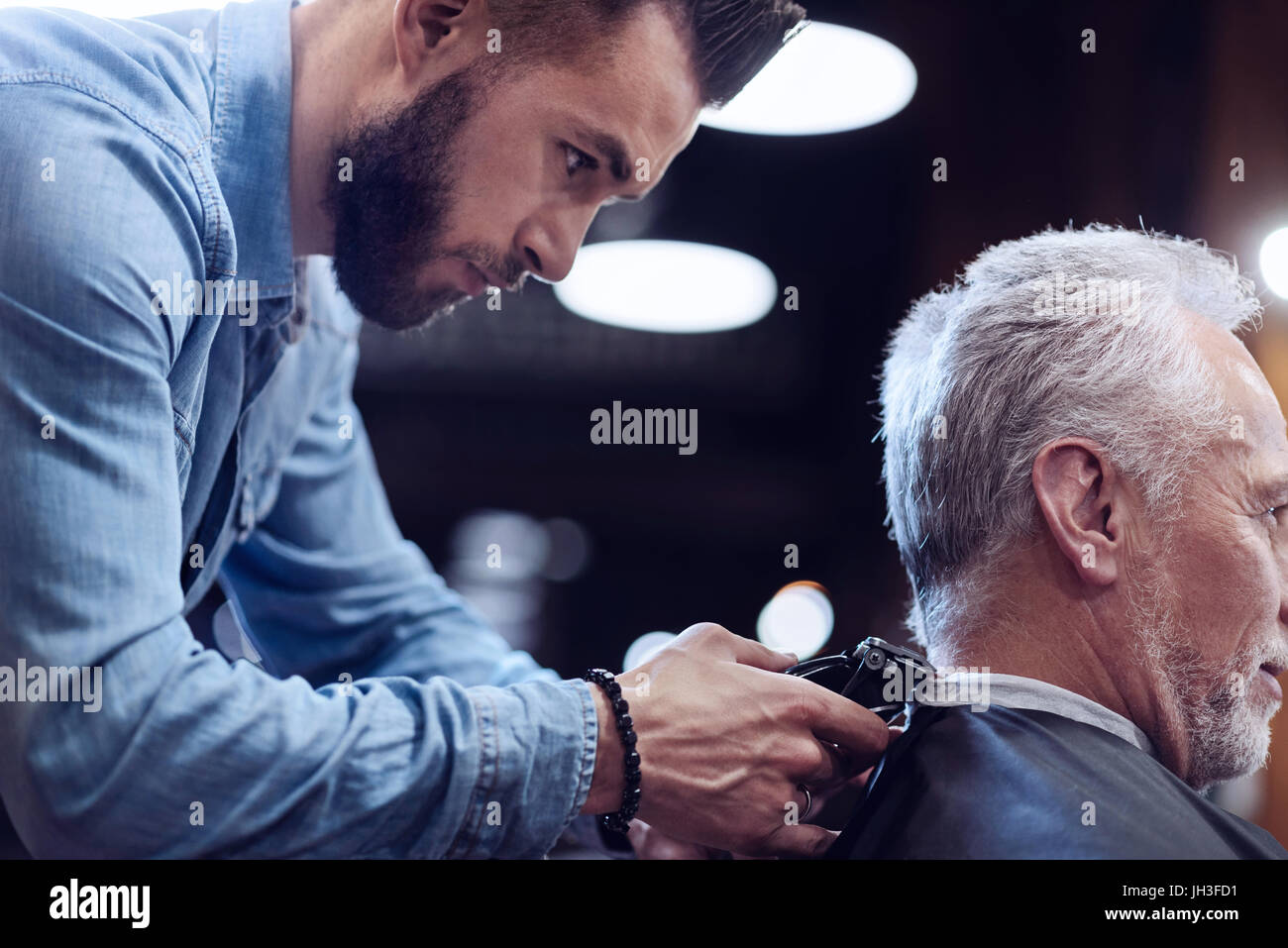 Schöne Männer Friseur auf seinen Job konzentrieren Stockfoto